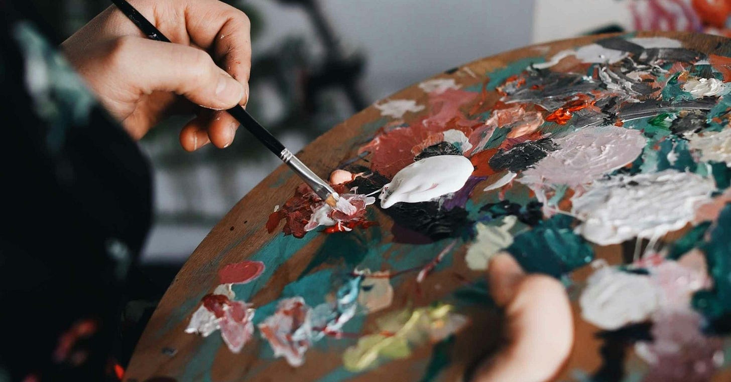 person holding paint brush while painting person holding paint brush while painting