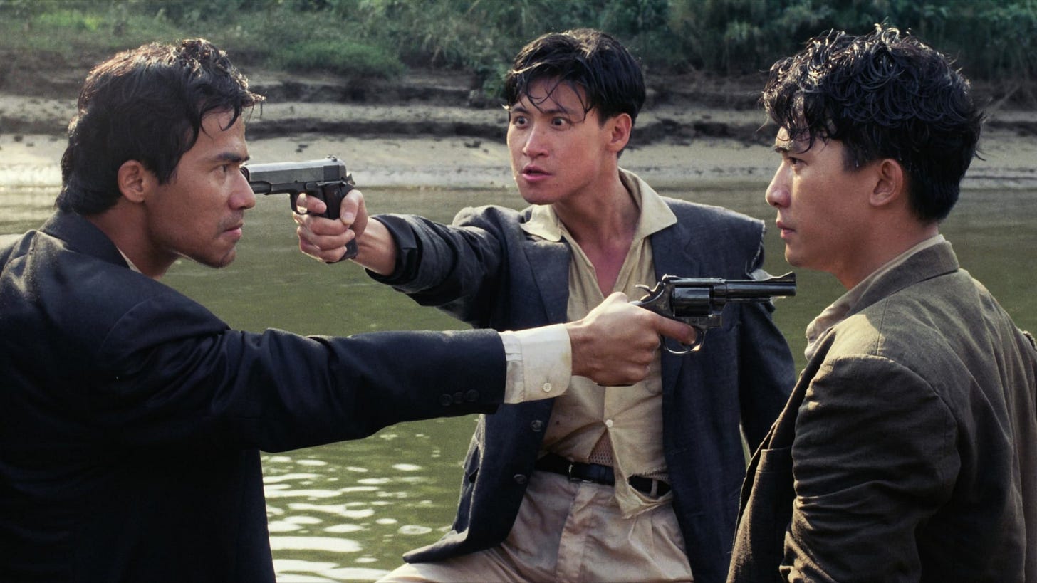 Bullet in the Head | Still features three men in a Mexican standoff.