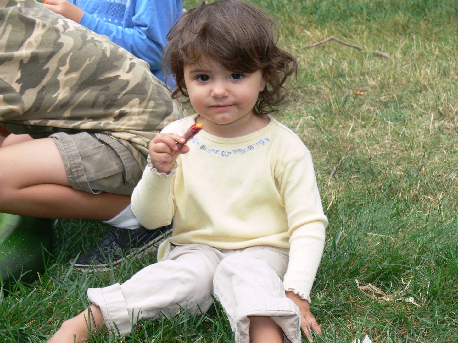 a girl eating a just-picked carrot