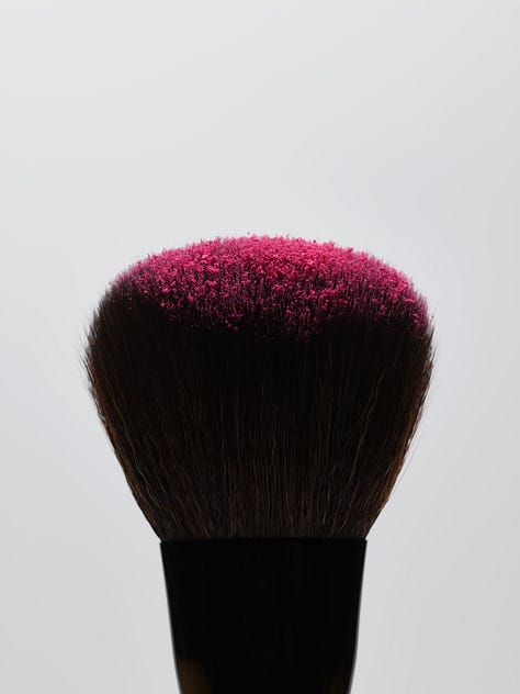 Three images: Six smears of blush; a makeup brush with bright pink blush on the end; and smears of hot pink blush.