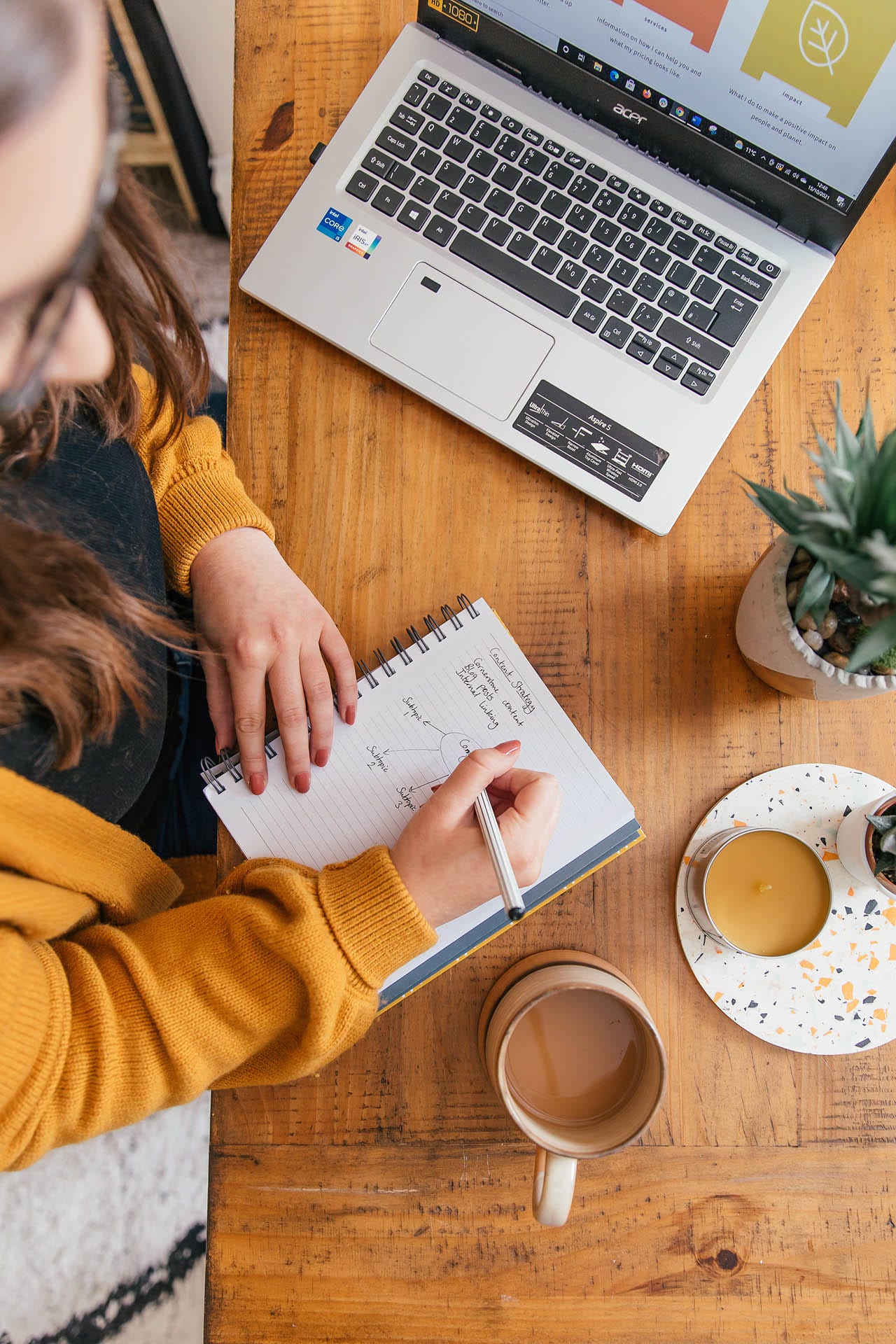 An overhead shot of Rachel at her desk, mapping out a content strategy in her notebook. On the page, the heading reads ‘Content strategy’. A list below reads: Cornerstone content; Blog posts; Internal linking. Below this is a mind map, which has three arrows coming out of a central circle, with space for brainstorming content ideas for three subtopics below each one.