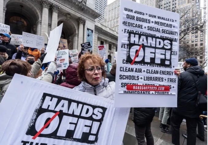 A person holding signs in front of a crowd

AI-generated content may be incorrect.
