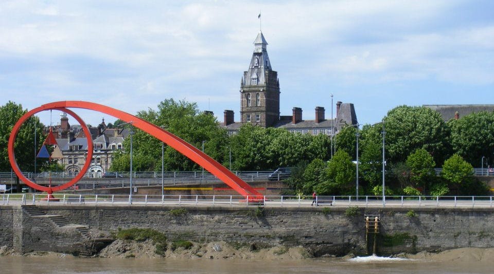 Newport, Usk riverbank, the Wave sculpture, trees, and Newport Market