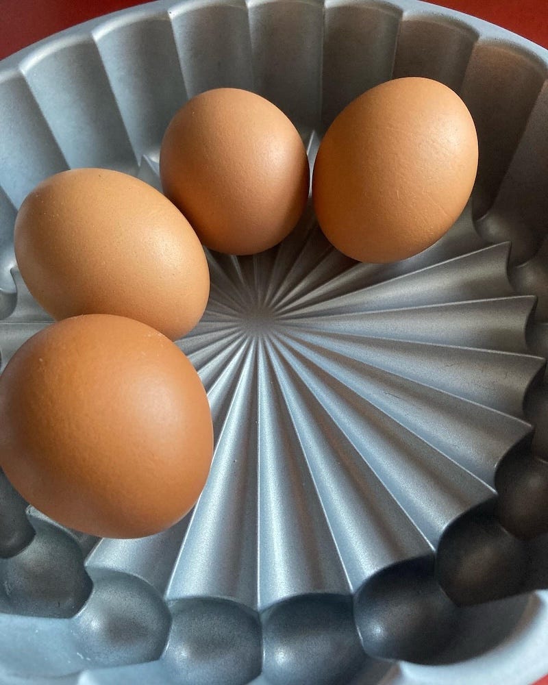 four brown eggs in a charlotte pan.