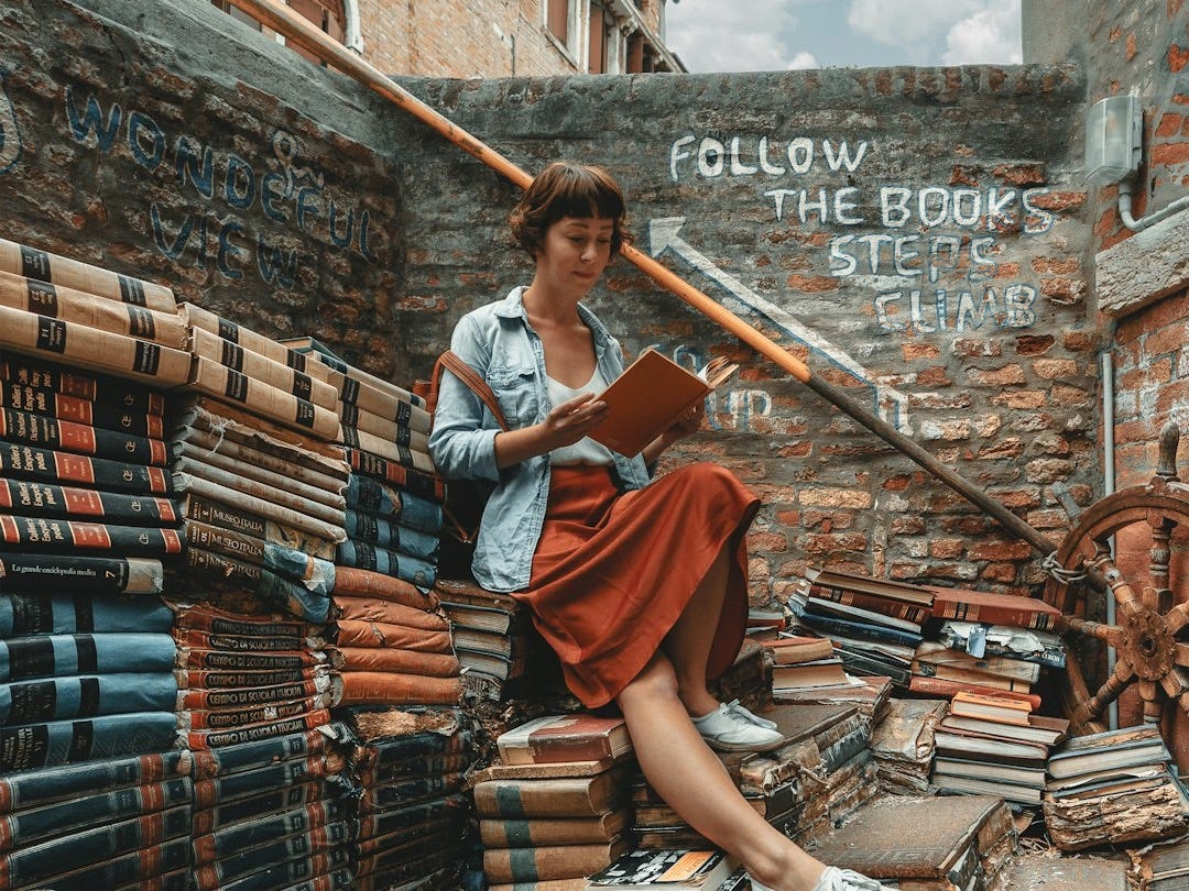 woman wearing denim jacket reading book