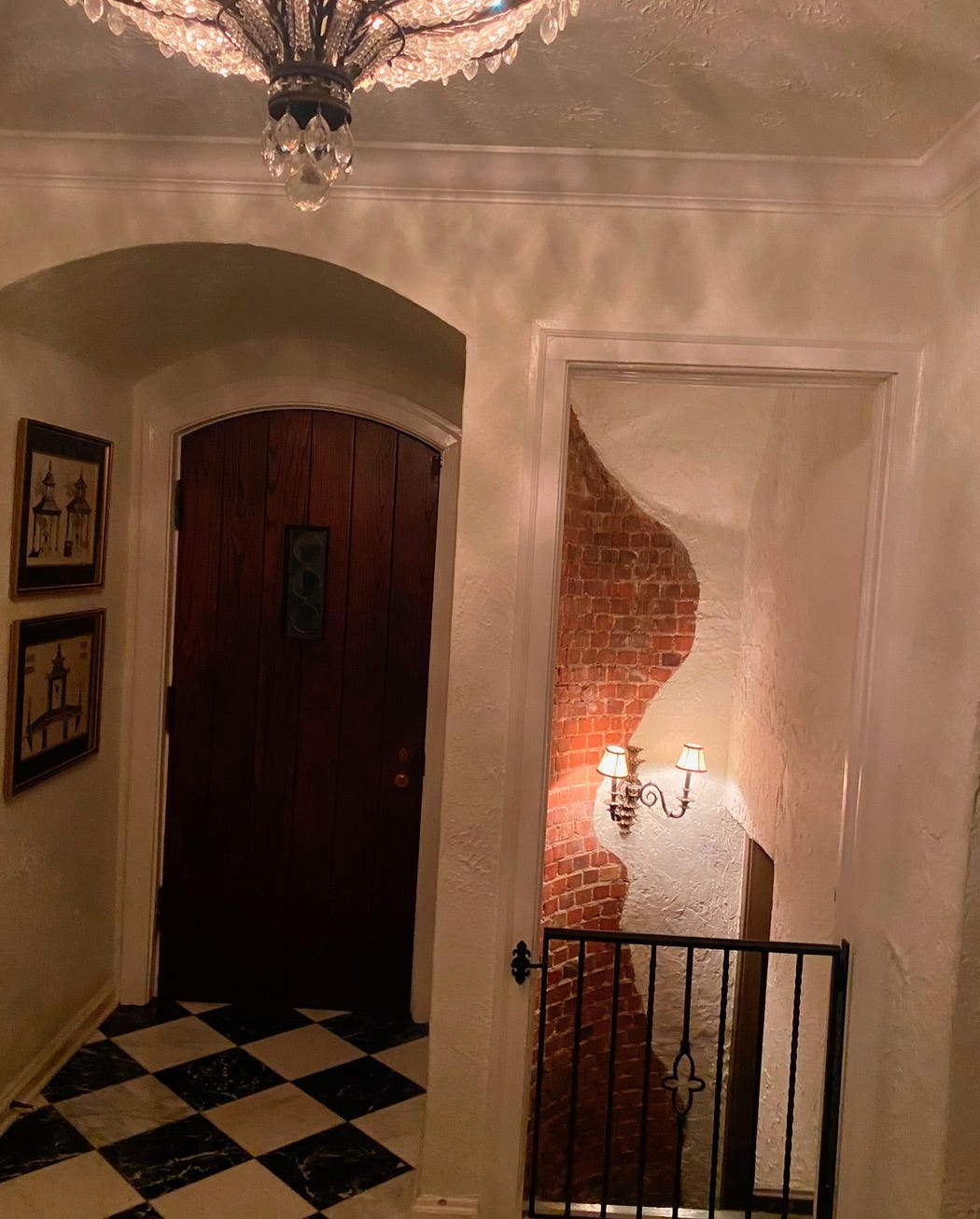 A hallway with a door and a black and white checkered floor

Description automatically generated