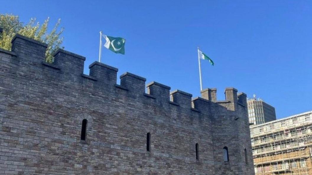Two green and white Pakistan flags, with a crescent moon and star, on flagposts on top of Cardiff castle