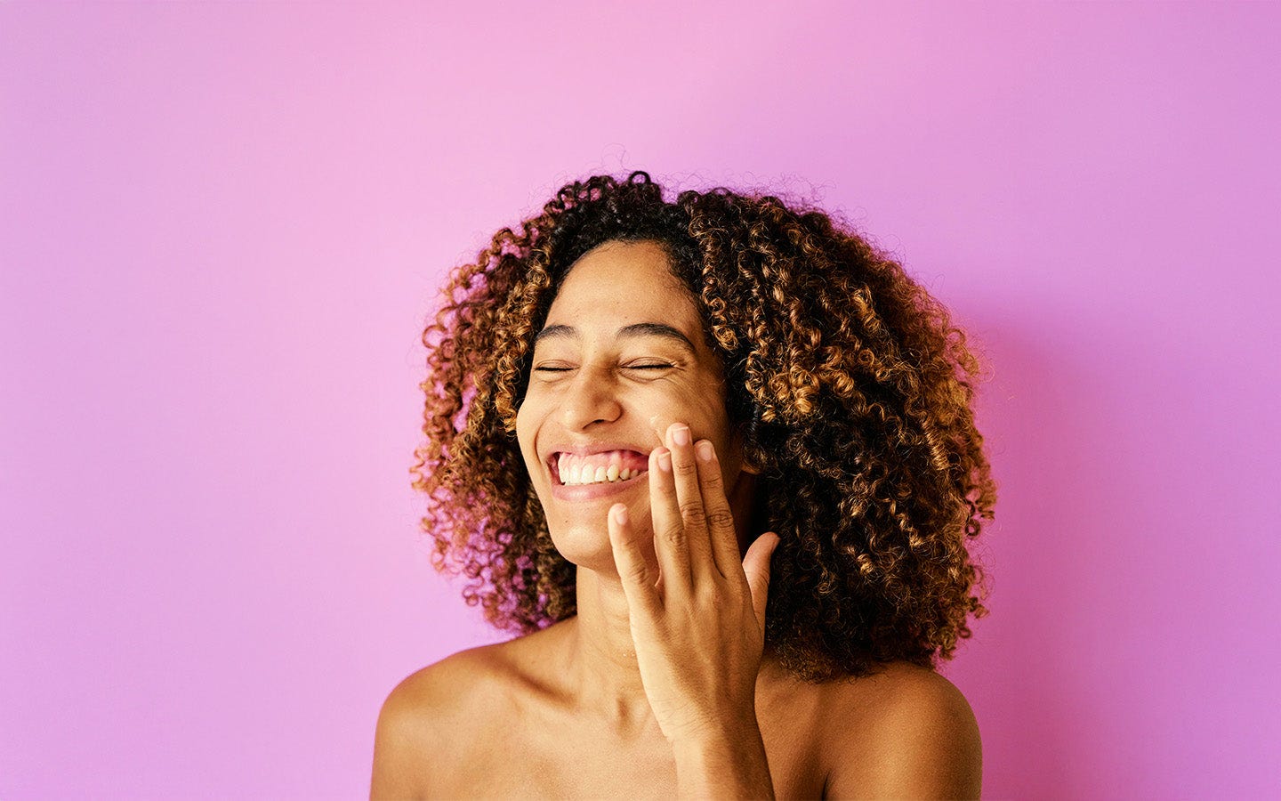 Woman smiling and touching her face
