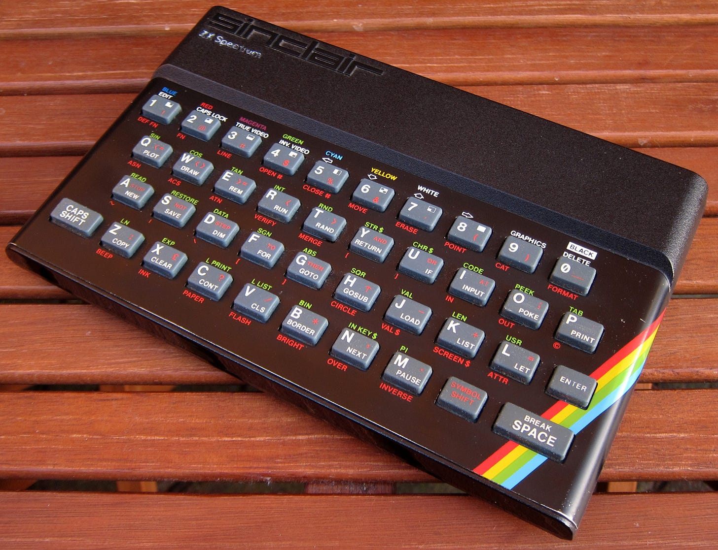 A slightly tatty-looking Sinclair ZX Spectrum 48K on a wooden table. 