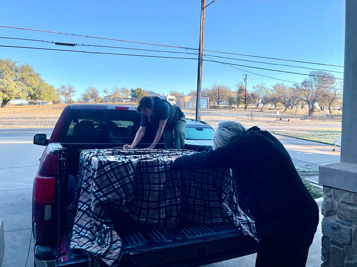 Photos of Bridgit and Sandy covering the armoire in the truck.