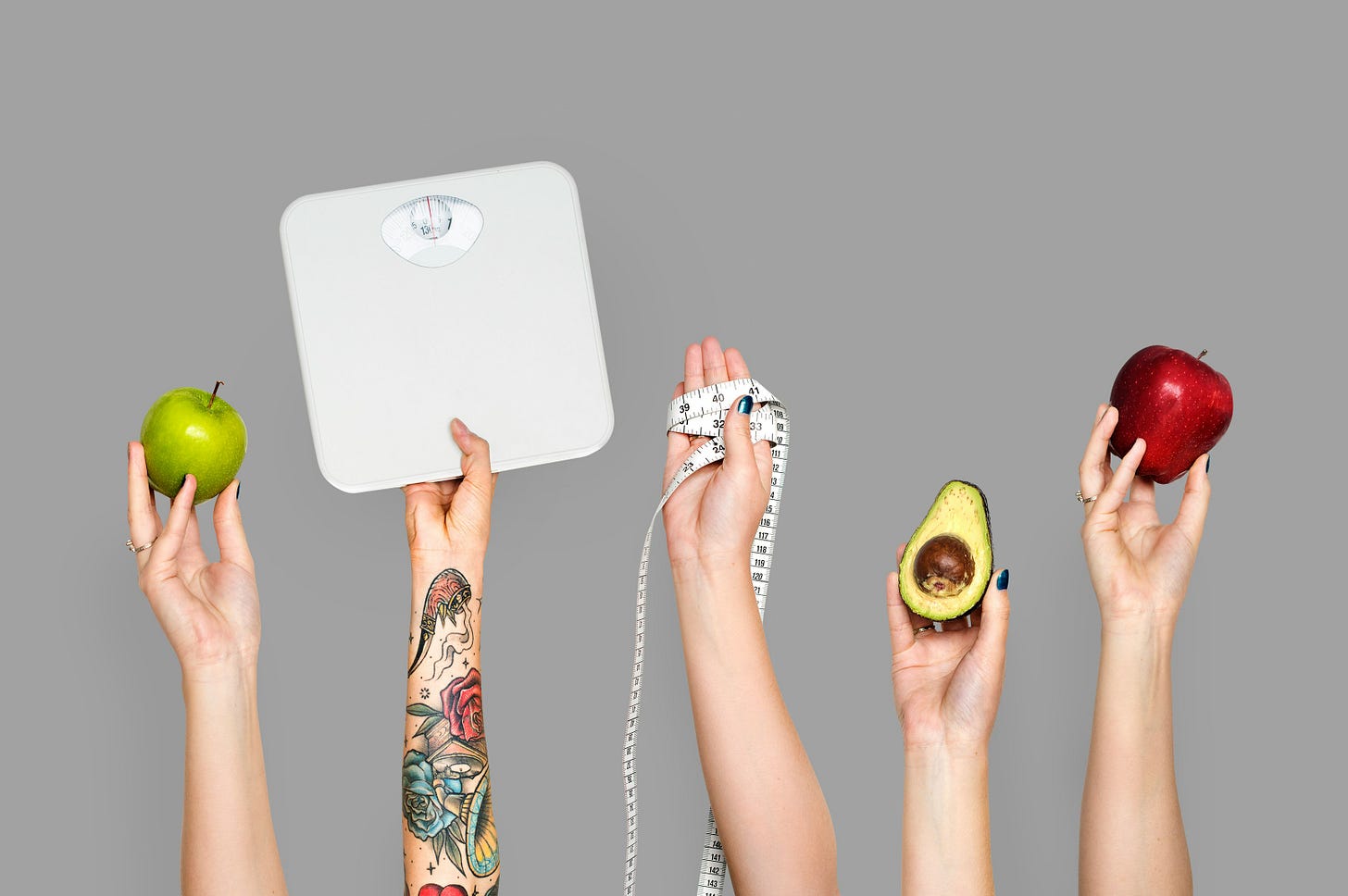 photo of hands holding scale, apples, measuring tape