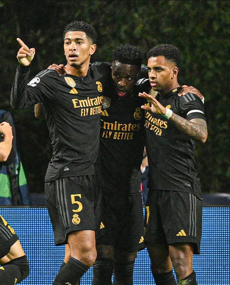 This may contain: the soccer players are celebrating their team's goal in front of an onlooker