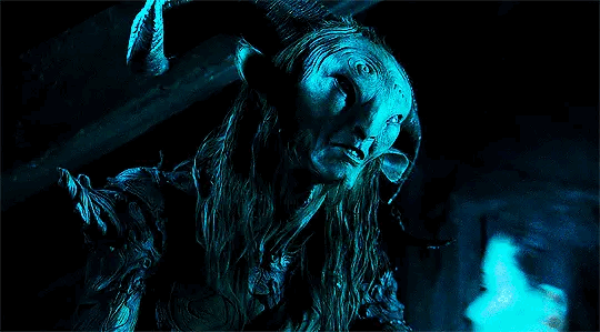 This may contain: a man with long hair and horns in the dark