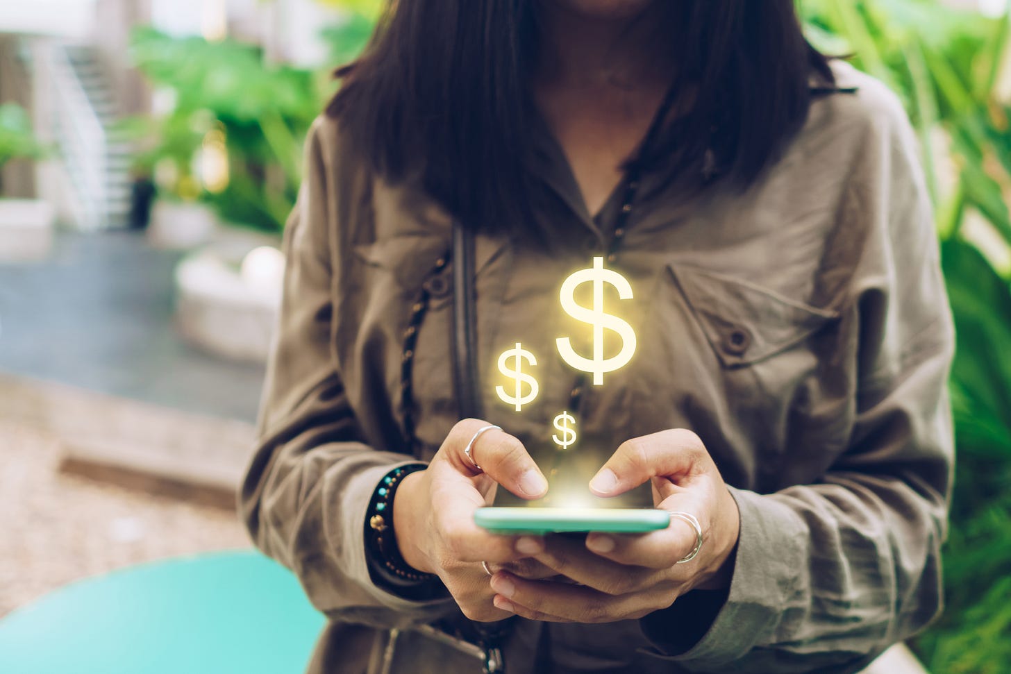 Dollar symbols rise from a smartphone