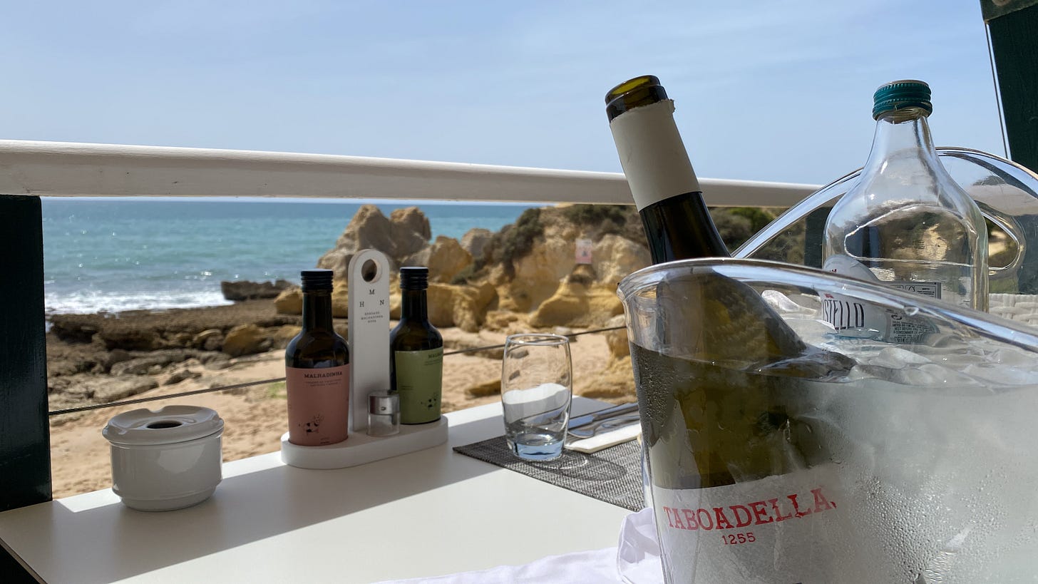A bottle of delicious Taboadella wine chilling in an ice bucket looking out at the Atlantic ocean in the Algarve, Portugal 