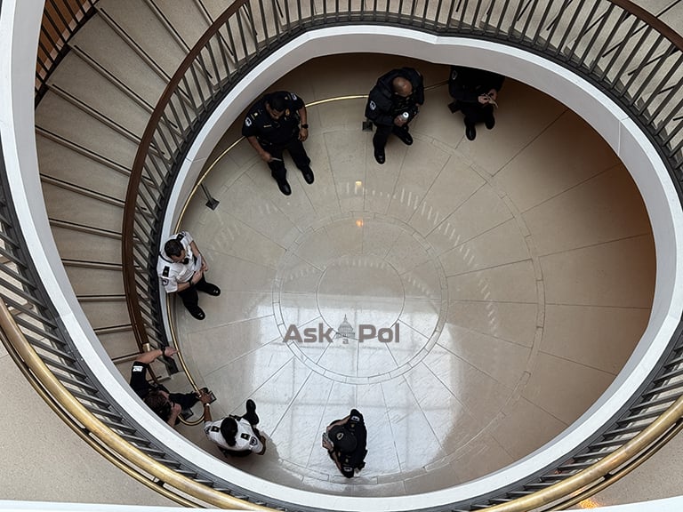 Police officers stand at the bottom of a windy large circular staircase at US Capitol. Photo Matt Laslo © www.askapol.com