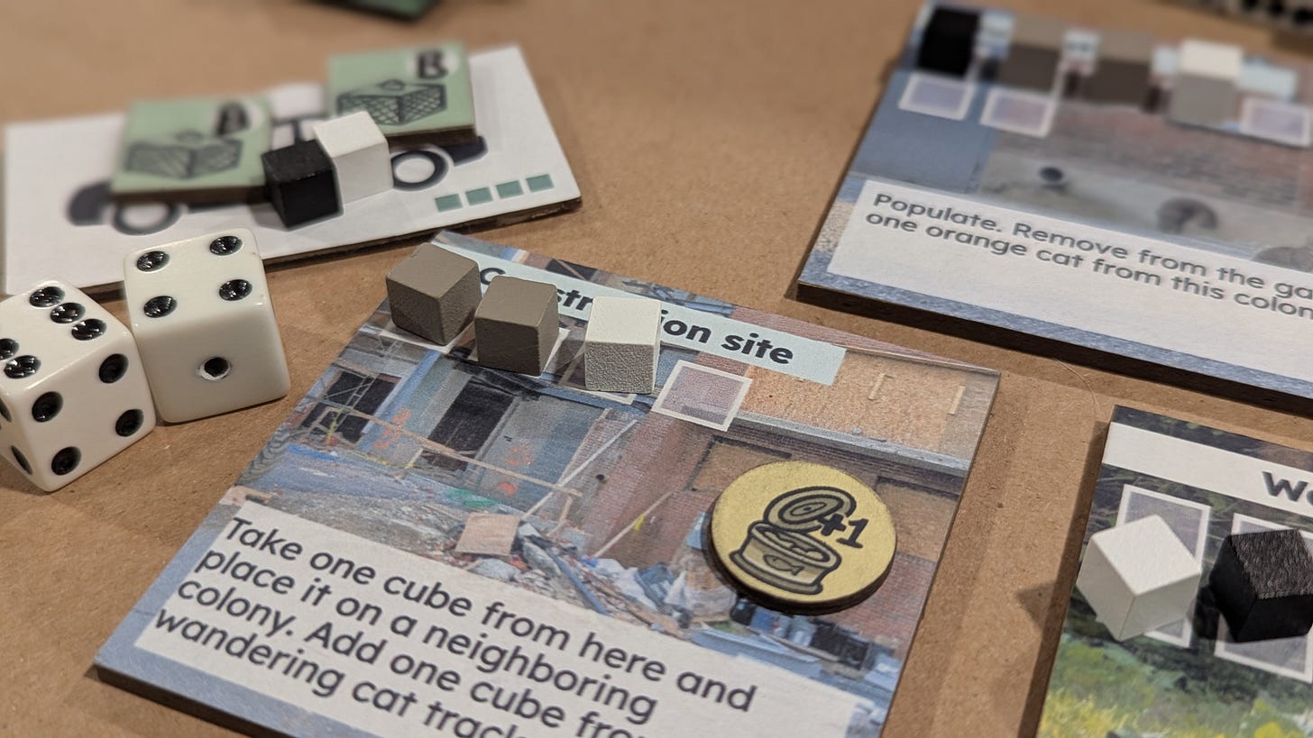 A location tile "Construction site" with two grey cube on it, two white dice, a car tile with two trap tokens on top. A location tile "Construction site" with two grey cube on it, two white dice, a car tile with two trap tokens on top.