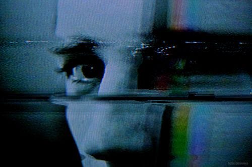 This may contain: a man in a suit and tie is reflected in a mirror with his eyes wide open
