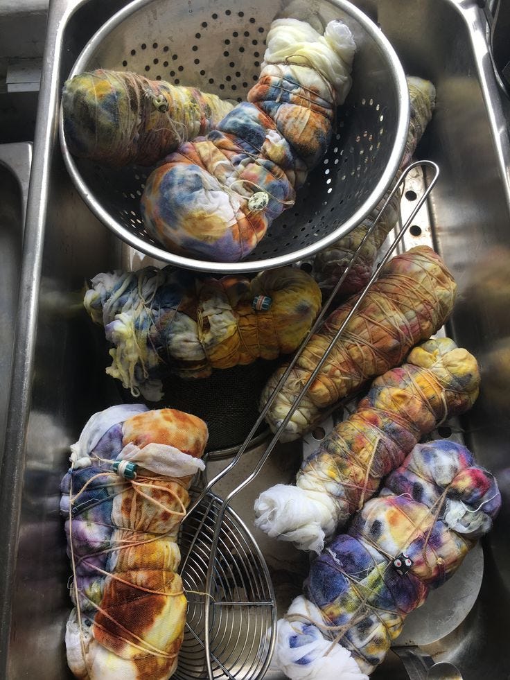 This may contain: several skeins of yarn are in a strainer