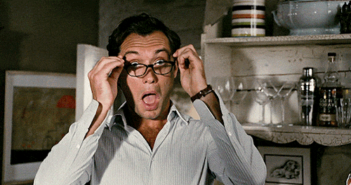 Jude Law putting on glasses in The Holiday