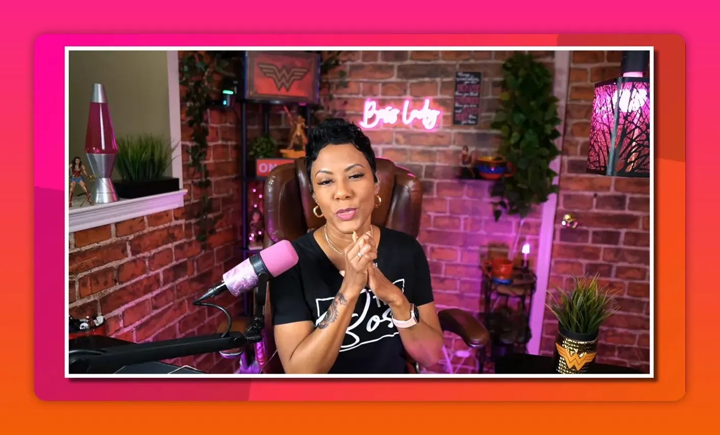 Host speaking from a well-lit live-stream studio with pink microphone and neon sign Host speaking from a well-lit live-stream studio with pink microphone and neon sign