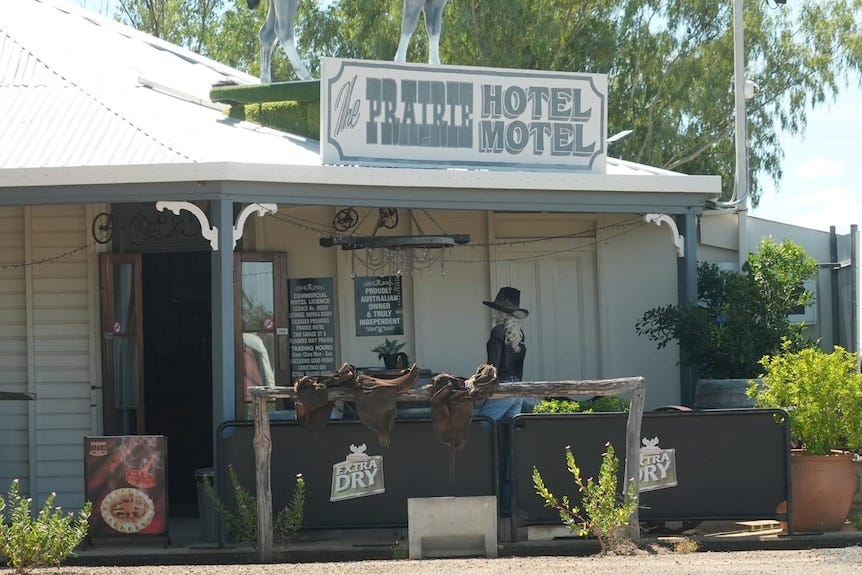 An Queenslander style outback pub with a sign which reads 'The Prairie Hotel Motel' An Queenslander style outback pub with a sign which reads 'The Prairie Hotel Motel'
