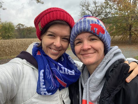 Two women smiling together in Buffalo Bills knit caps and scarves.