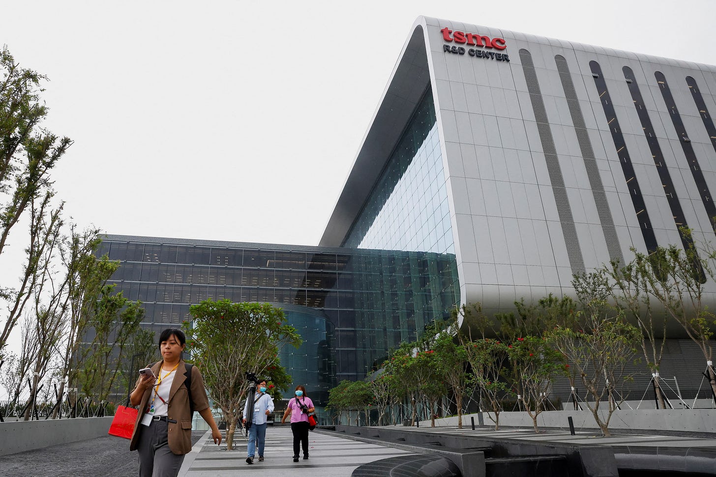 Members of the media walk outside of the TSMC global R&D center in Hsinchu