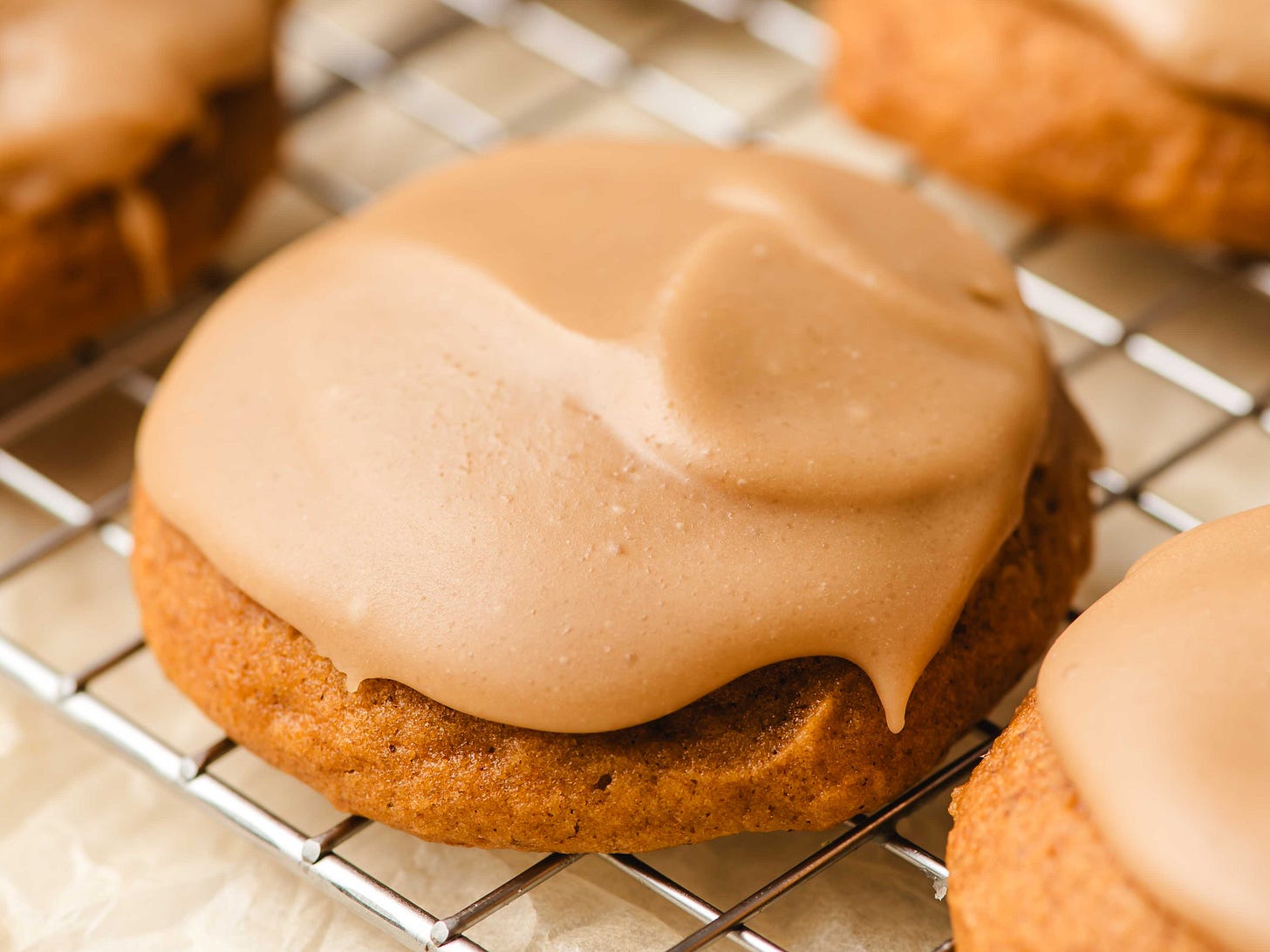 Pumpkin cookie with penuche frosting on a wire cooling rack