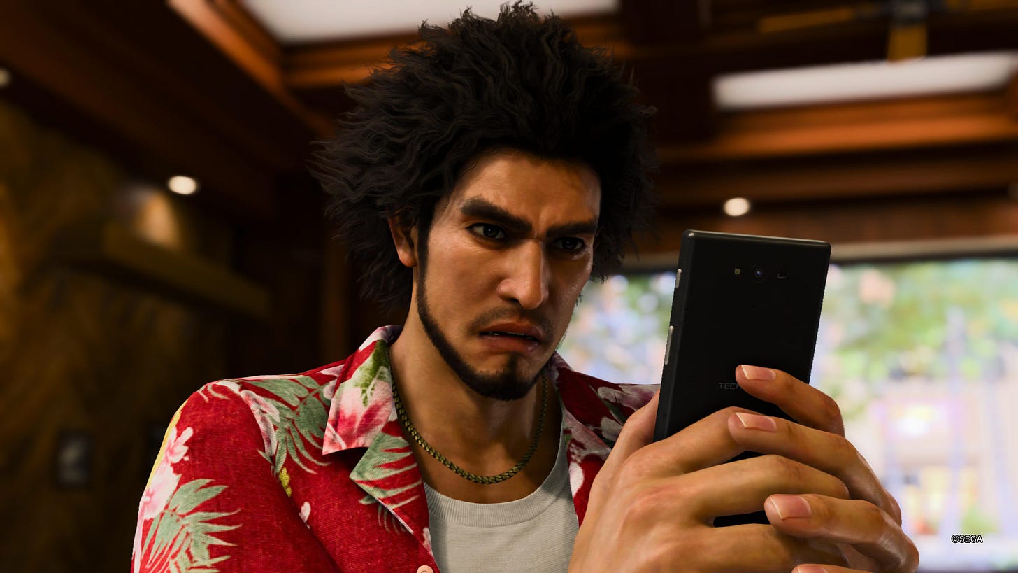 Ichiban from Like a Dragon: Infinite Wealth looks at his phone in anticipation.