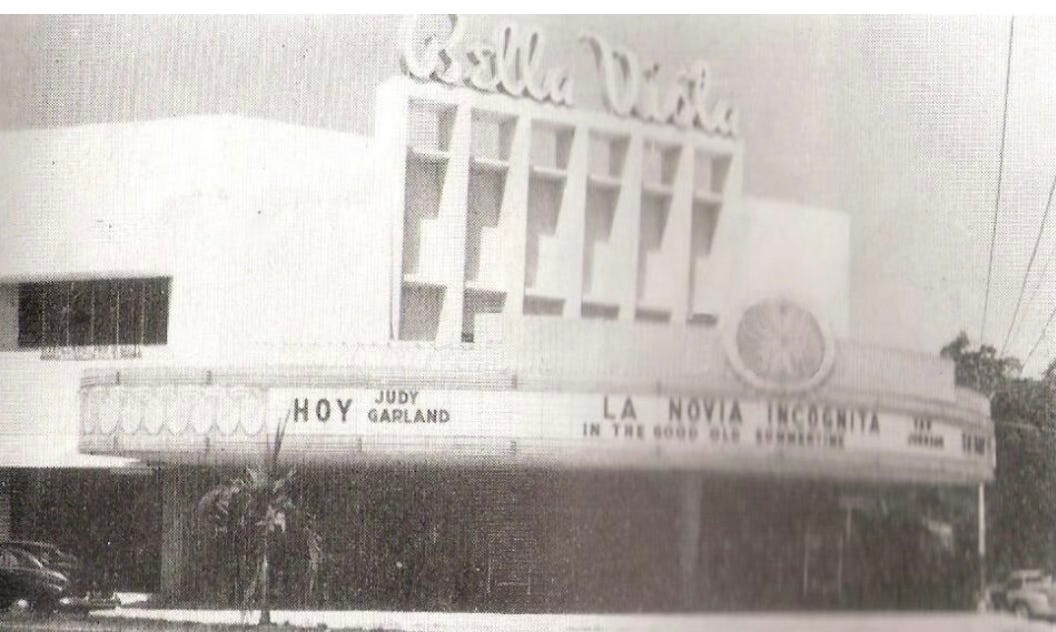 old white movie theatre wrapping a corner. Carved name at the top Bella Vista.