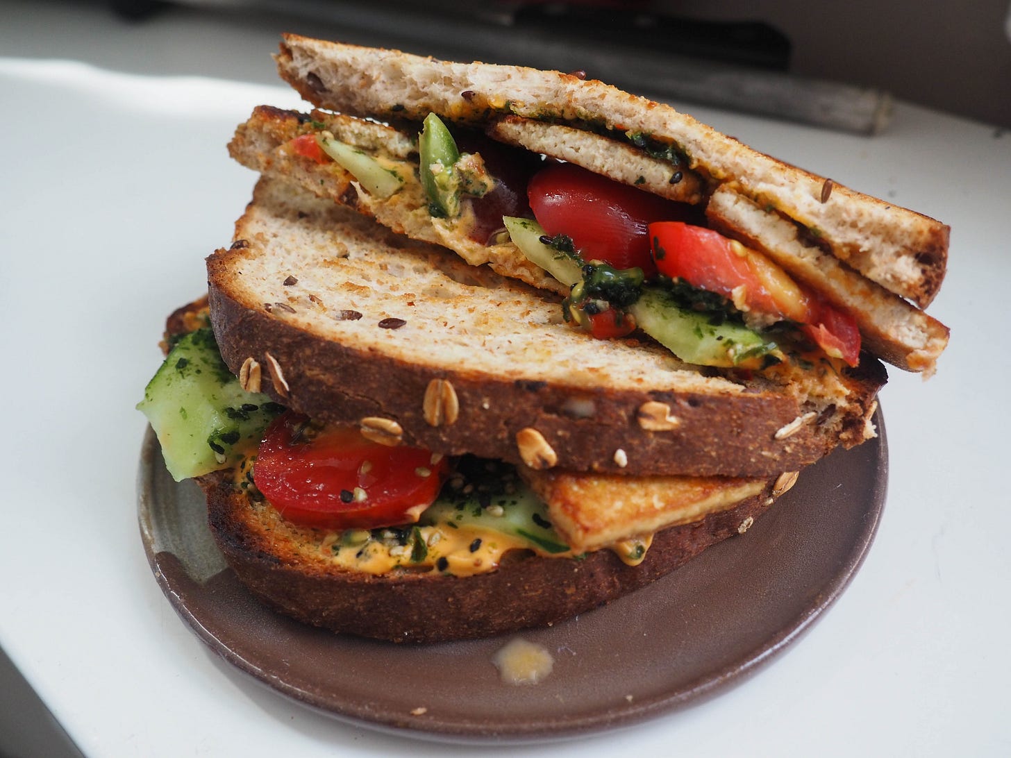 Tomato furikake sandwich with spicy mayo, cucumbers and smoky tofu.