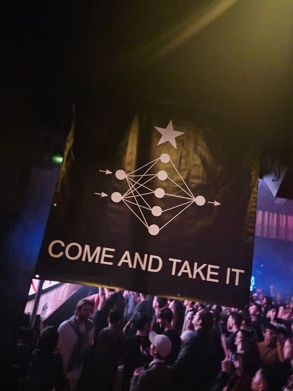 A brown sign with with white circles connected by lines and a start on top. Along the bottom are the words "Come and Take It."