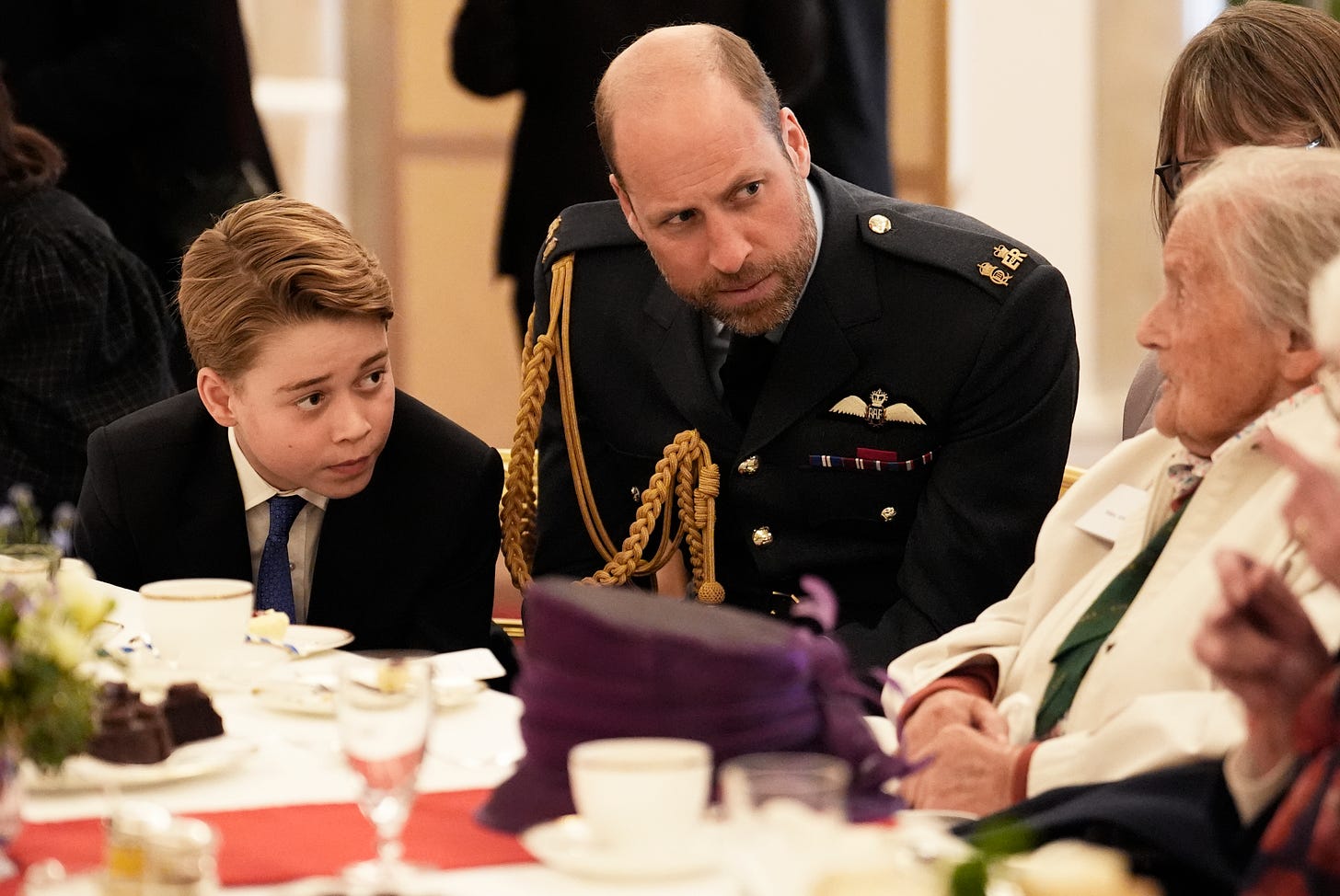 Prince George and Prince William listening intently to a veteran Prince George and Prince William listening intently to a veteran