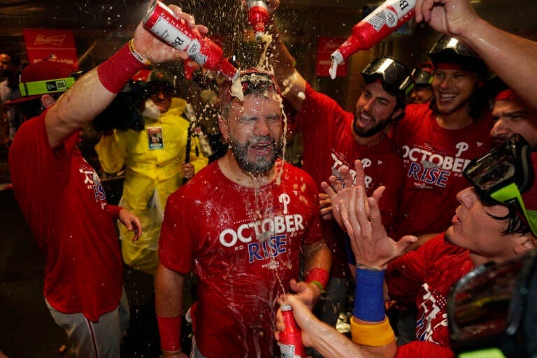 Philadelphia Phillies' Kyle Schwarber is doused in beer in celebration