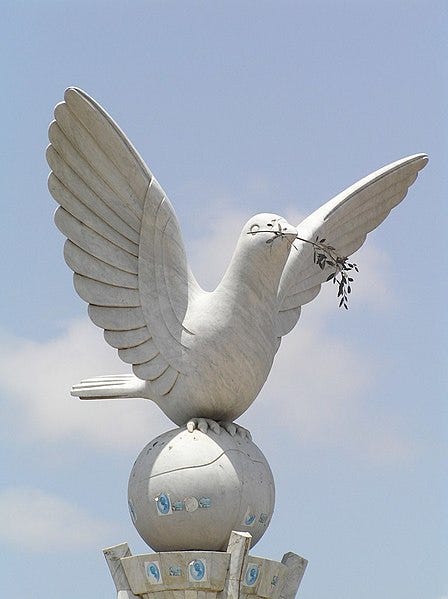 A statue of a dove with a branch in its beak

Description automatically generated