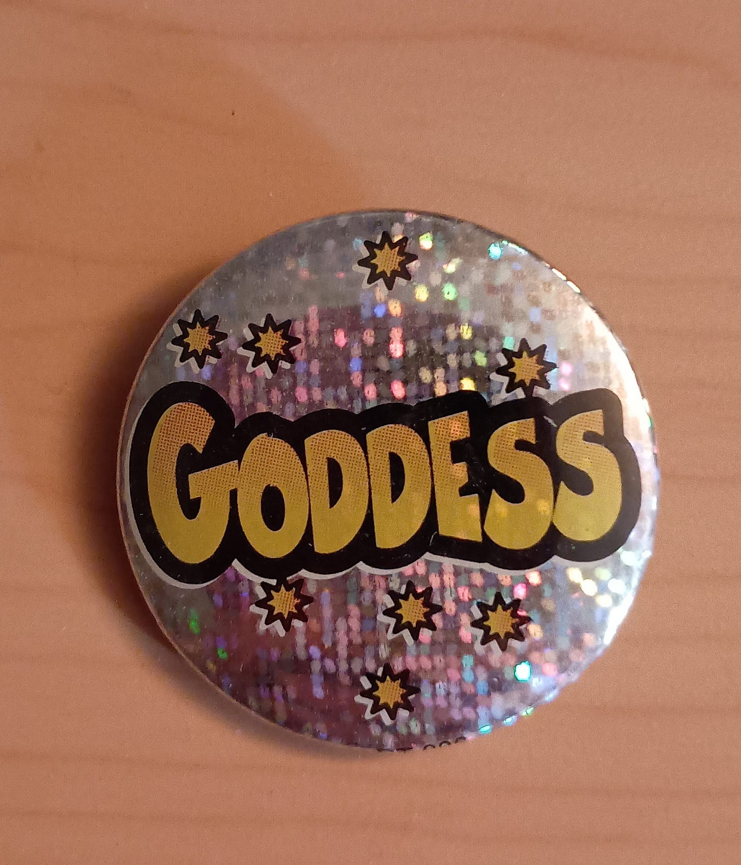a shiny pin that says Goddess
