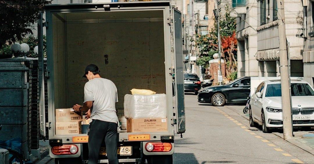a man unloading boxes from the back of a moving truck