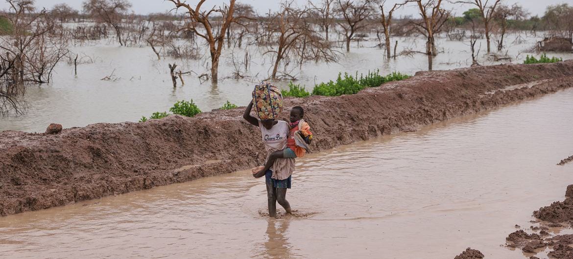 A displaced person walks along a flooded road in Bentiu, South Sudan.