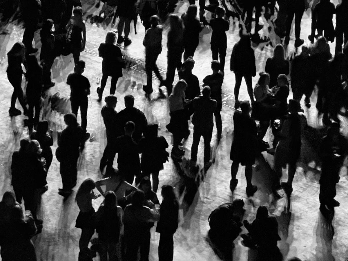 A black and white image of people milling around. A black and white image of people milling around.