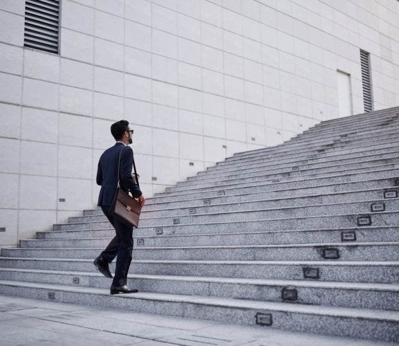 Business,Executive,With,Briefcase,Going,Up,The,Stairs