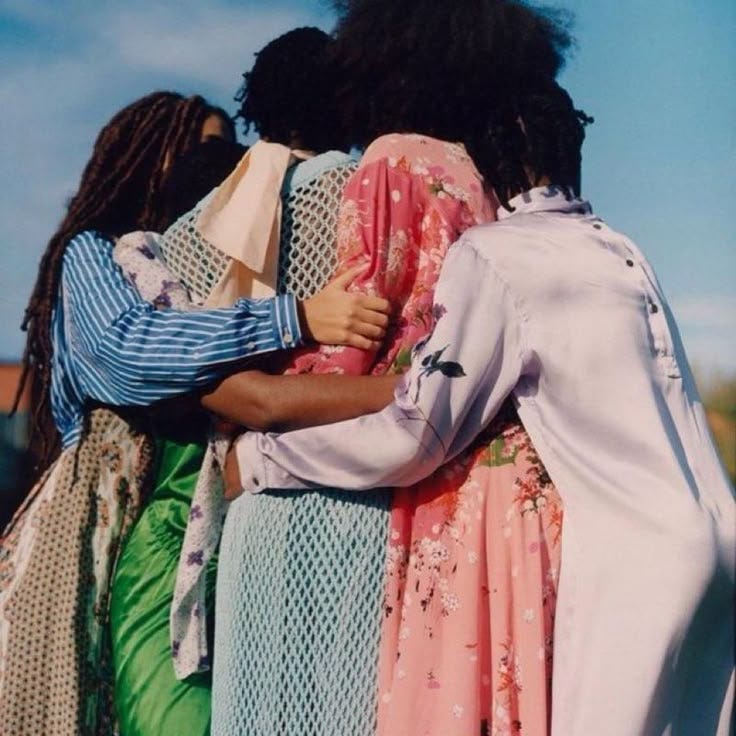 This may contain: two women hugging each other in front of blue sky
