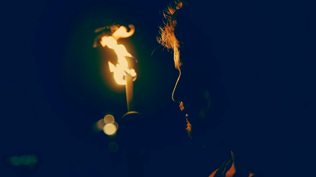 man standing in front of candle man standing in front of candle