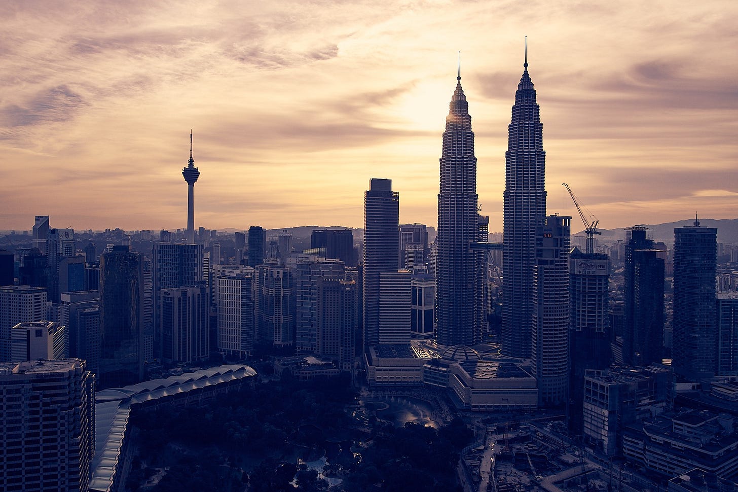 Kuala Lumpur skyline at sunset with the Petronas Twin Towers visible. Prime Minister Anwar Ibrahim is set to present Malaysia’s 2026 national budget on October 10, focusing on easing living costs, expanding subsidies, and sustaining fiscal discipline under the new five-year economic plan.