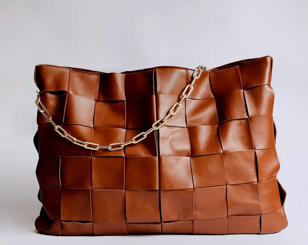 brown leather handbag on white surface