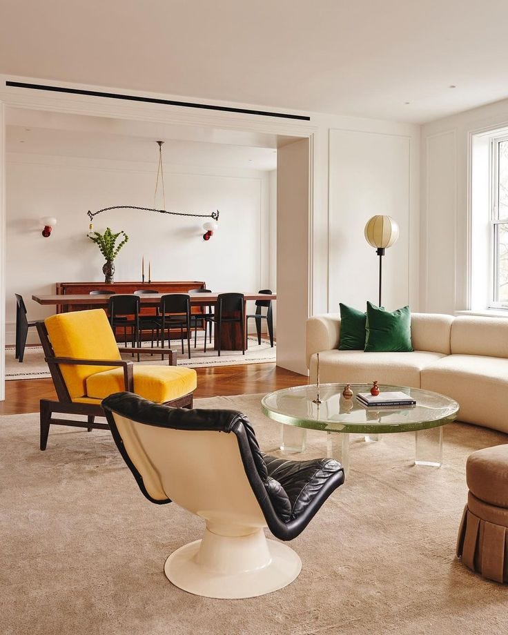 This may contain: a living room filled with furniture next to a table and chairs in front of a window