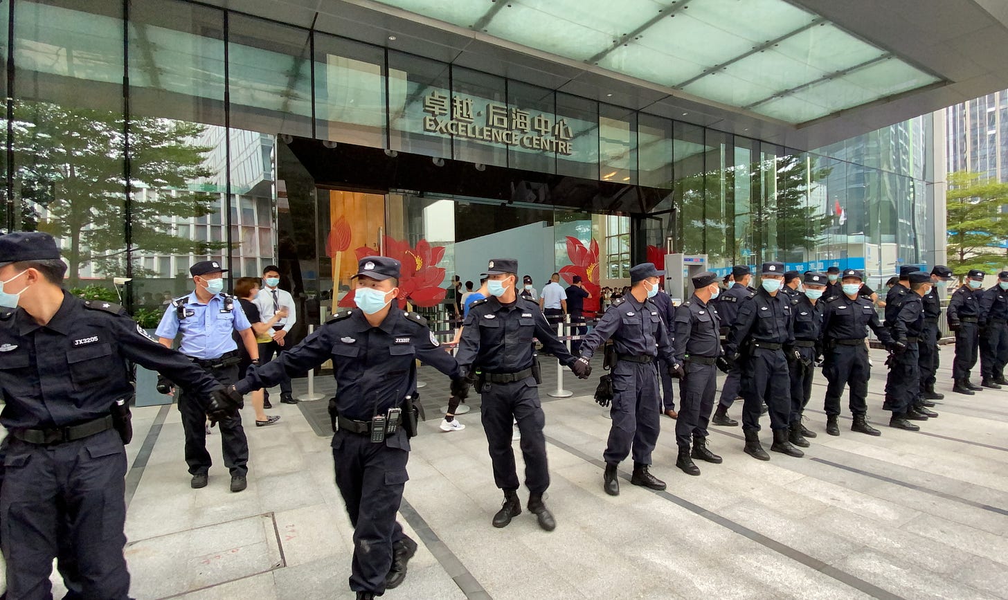 Security personnel form a human chain as they guard outside the Evergrande's headquarters, where people gathered to demand repayment of loans and financial products, in Shenzhen, Guangdong province, China September 13, 2021. REUTERS/David Kirton Security personnel form a human chain as they guard outside the Evergrande's headquarters, where people gathered to demand repayment of loans and financial products, in Shenzhen, Guangdong province, China September 13, 2021. REUTERS/David Kirton