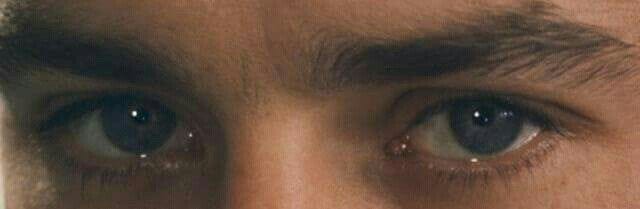 This may contain: a close up of a man's face with blue eyes