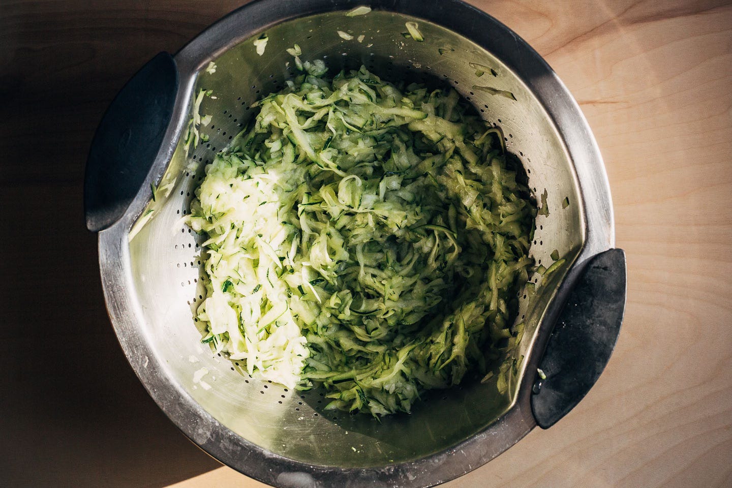 Shredded zucchini in a colander