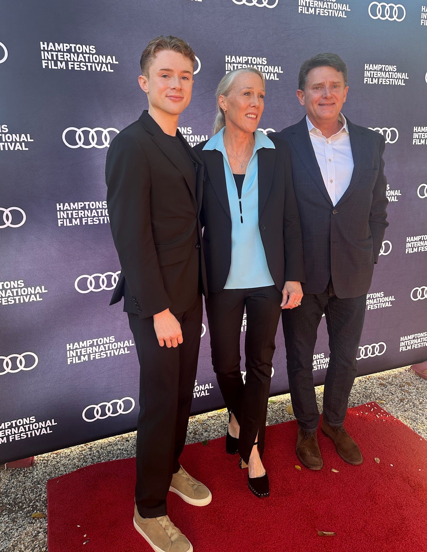 A group of people standing on a red carpet

AI-generated content may be incorrect.